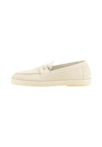 Mocasines de ante beige con una correa decorativa, que presentan una suela de esparto trenzada y un acabado suave. Diseño clásico y casual.