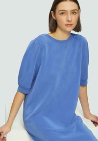 Bla dresses aus Baumwolle mit kurzen Puffärmeln und einem runden Halsausschnitt, die eine glatte Textur und eine lockere, entspannte Passform aufweisen.