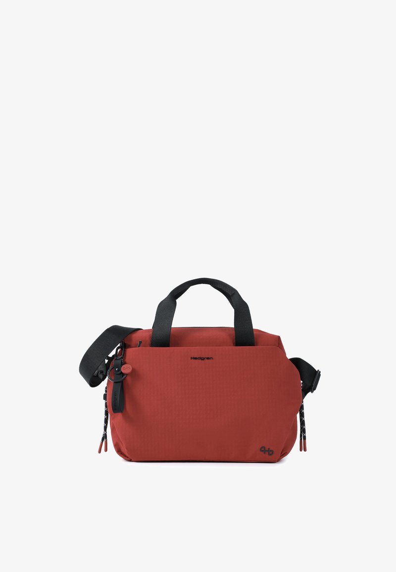 Sac rectangulaire rouge avec deux poignées noires et une bandoulière noire réglable, doté d'une poche zippée à l'avant et de petits logos de marque.