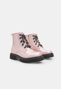 Roze cipele do gležnja s glitterom, crnim vezicama i bočnim patentnim zatvaračem. Imaju debeli crni đon i teksturiranu površinu s glitterom.