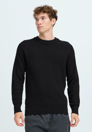 Schwarzer gerippter Strickpullover mit Rundhalsausschnitt und langen Ärmeln. Verfügt über einen strukturierten Stoff und einen leicht gewellten Saum.