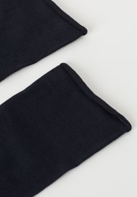 Calcetines de un azul marino oscuro, hechos de una tela suave y texturizada con bordes lisos, que presentan un diseño de canalé sencillo.