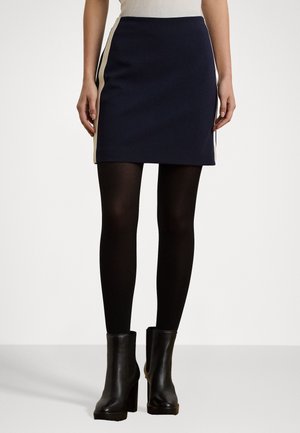 Navy mini skirt with cream side stripes, made from smooth fabric. Worn with black tights and heeled ankle boots.