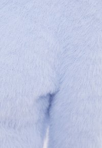 Tessuto lavorato a maglia di un blu chiaro soffice con una texture morbida e lanosa, che mostra dettagliati fili di lana e schemi di cucitura.