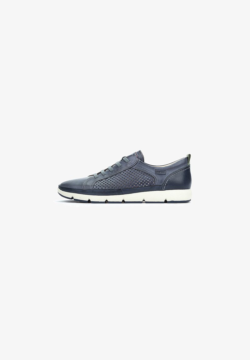 Zapatillas azul marino hechas de cuero suave y malla, con un diseño de perfil bajo, punta redonda y suela de goma blanca. Acentos horizontales visibles.