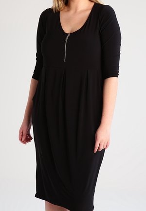 Czarna sukienka do kolan z miękkiego materiału, z okrągłym dekoltem, rękawami do łokcia i zamkiem błyskawicznym z przodu. Marszczony fason w talii.
