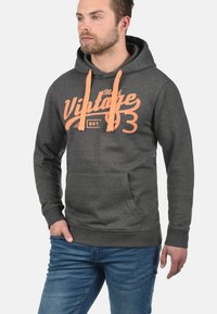 Grijze hoodie met oranje trekkoorden en een "Vintage 93" graphic op de voorkant. Voorzien van een kangoeroezak en ribgebreide manchetten en zoom.