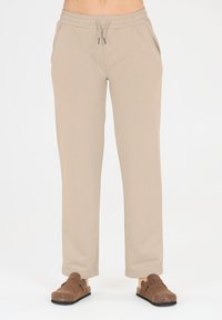 Beige Sweatpants mit einer lässigen Passform, elastischem Bund und Kordelzug. Verfügt über Seitentaschen und eine glatte, weiche Textur.