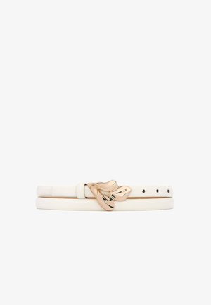 Biały skórzany pasek z dwoma kółkami, ozdobiony złotą klamrą w kształcie kwiatu z czarnymi akcentami. Gładka faktura z otworami na szpikulec do regulacji.