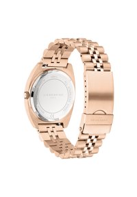 Montre en acier inoxydable rose doré avec un bracelet à maillons, un boîtier rond et un fond transparent affichant le logo de la marque et les détails de résistance à l'eau.