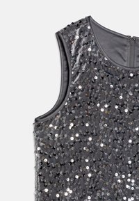Haut sans manches gris avec une texture douce, orné de paillettes argentées. Présente un col rond et une fermeture éclair à l'arrière.