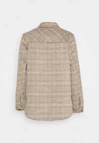 Chaqueta de camisa de cuadro marrón con cuello, mangas largas y puños abotonados. Fabricada en un tejido texturizado con patrones de cuadros claros y oscuros.