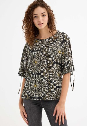Blusa negra de manga corta con patrón floral en blanco y amarillo. Presenta un escote redondo y lazos ajustables en las mangas.