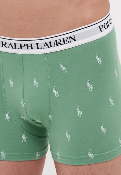Zelene pamučne muške bokserice s uzorkom bijelih polo igrača. Imaju bijeli pojas s natpisima "RALPH LAUREN" i "POLO" otisnutim u crnoj boji.