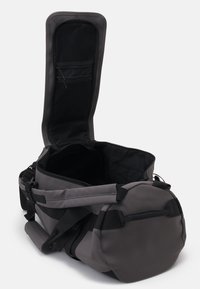 Graue Reisetasche aus einem strapazierfähigen Material, mit einem Reißverschluss-Hauptfach, verstellbaren Trägern und einer Seitentasche zur Aufbewahrung.