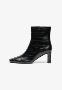Botine negre cu vârful ascuțit, exterior glossy cu textură de crocodil și toc pătrat de înălțime medie. Design neted și elegant.