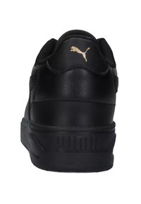 Czarny sneaker z teksturowaną skórzaną cholewką, z złotym logo na pięcie i grubą, wzorzystą podeszwą zapewniającą wytrzymałość i styl.