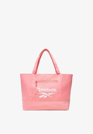 Bolso tote rosa de Reebok con dos asas y un bolsillo frontal con cremallera que muestra el logo blanco de Reebok y un diseño vectorial.