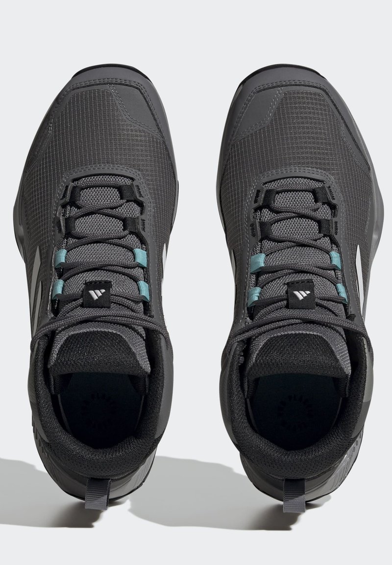 Czarne buty sportowe z texturedową siateczką u góry, kontrastującymi tealowymi sznurowadłami i wzmocnioną piętą. Posiadają wyściełany kołnierz i detal z logo.