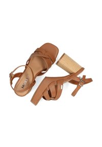 Brown strappy high-heeled sandals with a woven-textured block heel. Features ankle straps and a flat, square toe design.