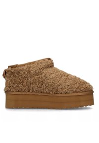 Zapatilla de plataforma marrón con exterior texturizado y esponjoso y punta redondeada y lisa. Presenta una altura de tobillo y una tira en la parte posterior.
