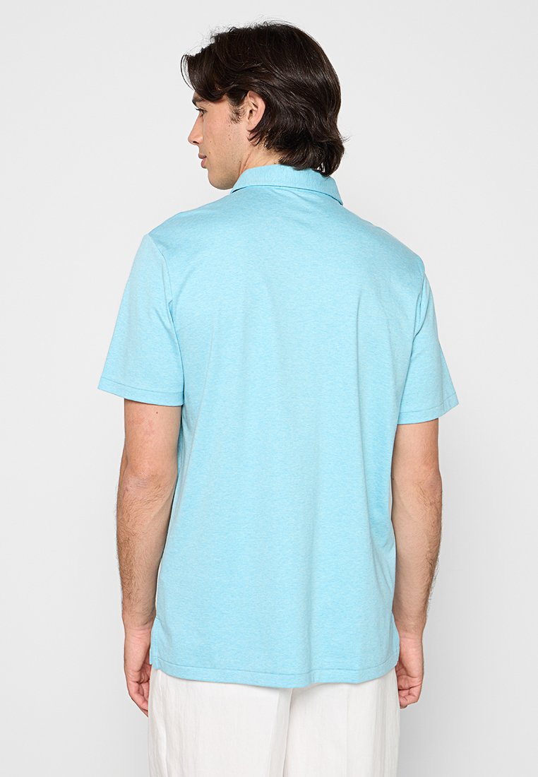 Jasnoniebieska koszulka polo wykonana z miękkiego materiału, z krótkimi rękawami, kołnierzykiem i prostym dołem. Tył ma gładką fakturę.
