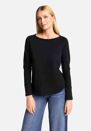 Zwarte lange mouwen top met een ronde halslijn, een soepele textuur en subtiele stiksels, in combinatie met lichtblauwe jeans.