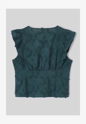 Blouse bleu sarcelle à manches courtes avec manches volantées et motif brodé floral en relief sur tissu lisse, posée à plat sur fond gris.