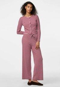 Röd och vit randig pyjamas set med lång ärm, knappar och dragsko i midjan. Mjuk tyg, lös passform, vida ben och platta tofflor.