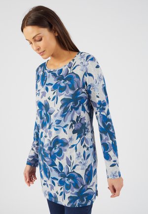 Langarm tuniek in lichtgrijs met een blauw bloemmotief, voorzien van een ronde halslijn, zijsplitten en een relaxed fit. Zachte stofstructuur.