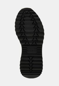 Suola di scarpa in gomma nera con un design testurizzato che presenta motivi triangolari, rilievi e il marchio inciso "GUESS."