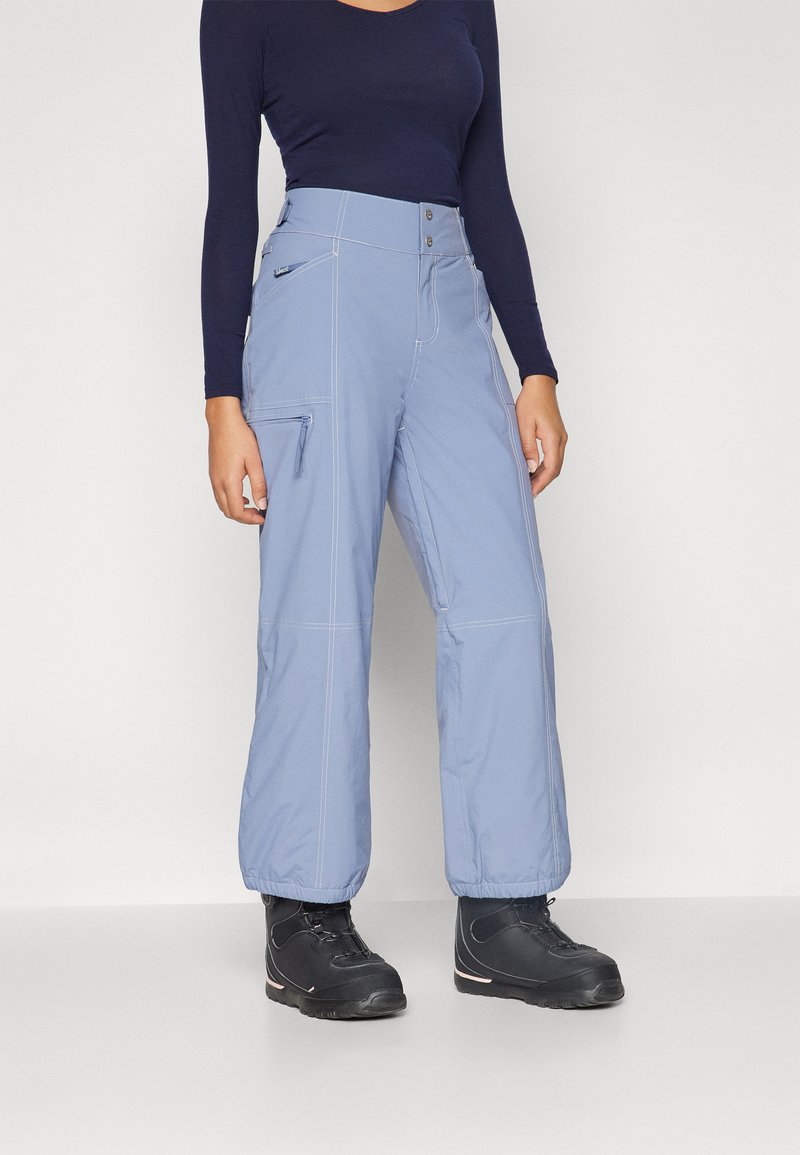 Light blue snow pants with a relaxed fit, featuring a zippered pocket, contrast stitching, and worn with black winter boots.