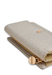 Beige zippered wallet with a textured finish, gold hardware, and a circular zipper pull featuring brand detail.