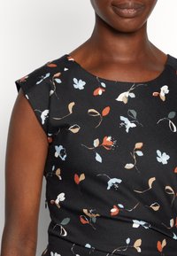 Vestido floral com fundo preto, apresenta mangas curtas, decote redondo e uma mistura de padrões florais azuis, vermelhos e beges em tecido texturizado.