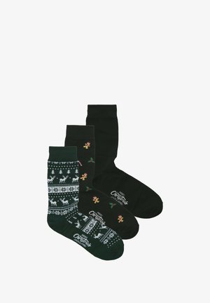 Drie paar sokken: donker groen met rendieren en sneeuwvlokken patroon, effen donker groen, en zwart met peperkoekmannetjes en hulst accenten.
