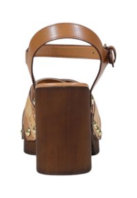 Sandalo platform in pelle marrone chiaro con un chunky tacco a blocco marrone, cinturino alla caviglia posteriore e borchie decorative sul materiale superiore.
