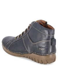 Dark blue leather ankle boot with beige stitching, rubber sole, and a rear pull tab. Features curved design and textured surface.