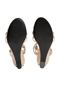 Sandales à talons nudes avec un dessus lisse et un design entrecroisé ; semelles en caoutchouc noir avec des rainures horizontales pour une meilleure adhérence.