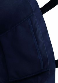 Námořnická modrá textilní batoh s strukturovaným povrchem, vybavený přední kapsou a černými nastavovacími popruhy, zdůrazněný čistým šitím.