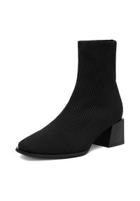 Czarny botek do kostki wykonany z rozciągliwego materiału dzianinowego, z ostrym czubkiem i masywnym obcasem. Żebrowana faktura na górze.