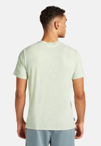 Lys grøn kortærmet t-shirt med afslappet pasform, lavet af blødt stof. Har en rund halsudskæring og flade sømme for komfort.