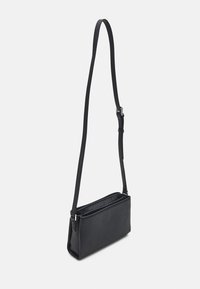 Borsa a tracolla nera in pelle con superficie texturizzata, forma rettangolare allungata, tracolla regolabile e chiusura con zip.