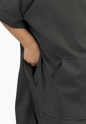 Graues, weiches Stoffkleidungsstück mit lockerer Passform, kurzärmlig und mit einer Vordertasche, das eine glatte Textur und ein lässiges Design betont.