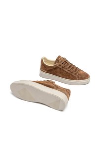 Sneakers in suede marrone con lacci piatti, suola in gomma color crema e delicato marchio sul lato, caratterizzate da una tomaia testurizzata e una linguetta liscia.