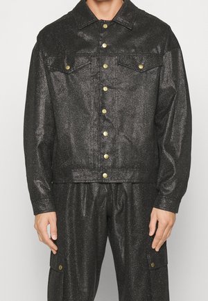Giacca di jeans nera, metallica, con chiusura a bottoni frontale, due tasche sul petto e colletto classico. Leggero luccichio con dettagli in hardware dorato.