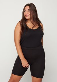 Black tank top with lace trim and ribbed texture paired with black stretchy shorts. Fitted design with an elastic waistband.