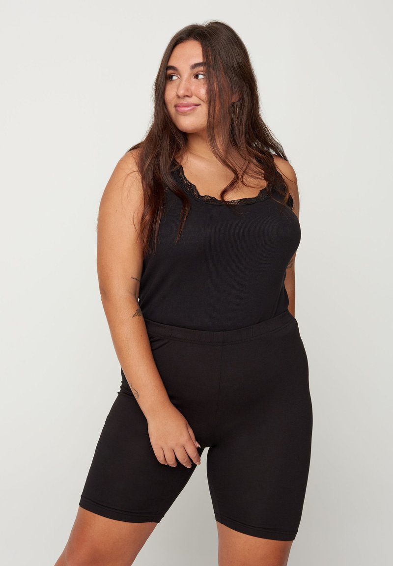 Black tank top with lace trim and ribbed texture paired with black stretchy shorts. Fitted design with an elastic waistband.