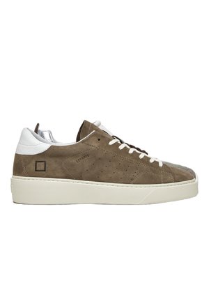 Sneaker in suede marrone con un tallone in pelle bianca, lacci piatti e suola in gomma con texture. Perforazioni notevoli lungo il lato.
