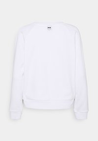 Vit långärmad sweatshirt sedd bakifrån med en liten svart logga nära halsringningen.