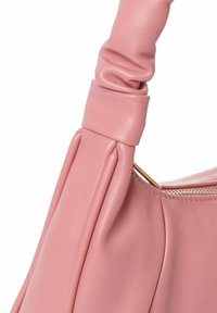Borsa in pelle rosa con un manico morbido e arricciato e una zip dorata. Texture liscia con un design minimalista.